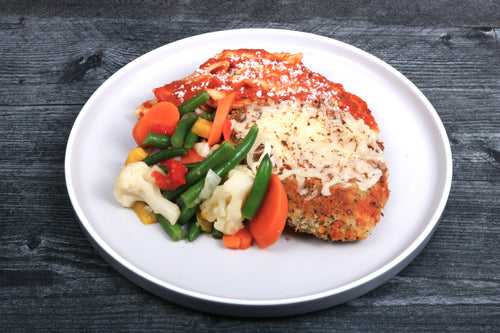 Chicken Parmesan Plated dish with breaded cutlet, vegetables, and cheese.