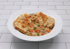 Chicken Pot pie with vegetables in a white bowl on a tiled floor